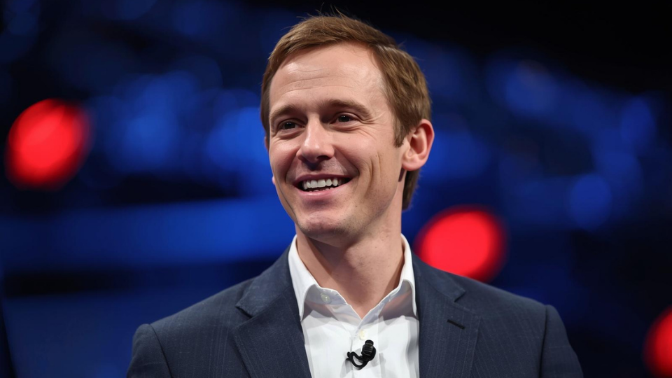 A realistic photo of Sierra co-founder and OpenAI chairman Bret Taylor speaking at an event.