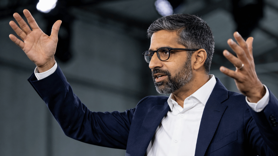 Alphabet CEO Sundar Pichai gesturing with his hands during a professional presentation on stage.