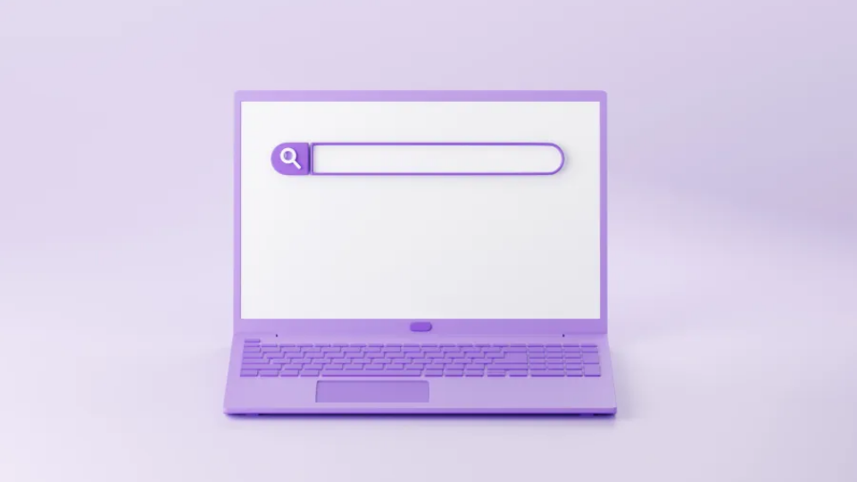 A close-up view of an open purple laptop displaying a clean web browser interface with a central search bar on a white desk.