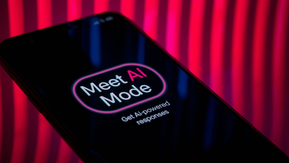 A close-up view of a smartphone screen displaying the words Meet AI Mode inside a glowing neon border.