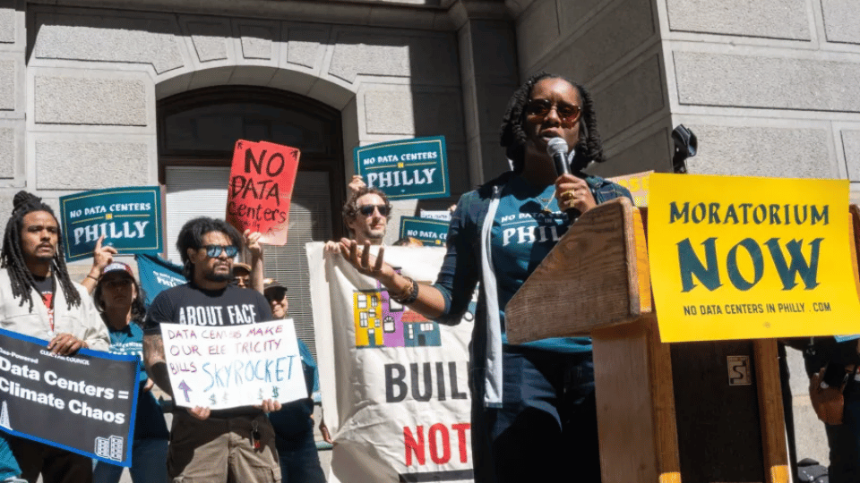 Community members holding protest signs outside a city hall building.