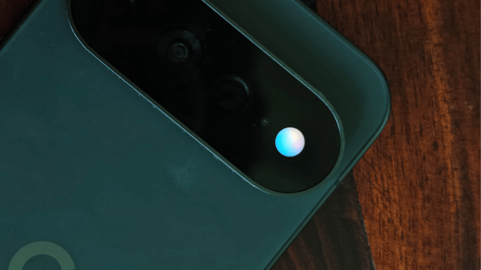 A Google Pixel smartphone resting on a wooden surface showing an active voice call screen.