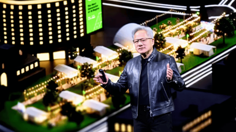 Nvidia CEO Jensen Huang standing on stage in a black leather jacket near a lit model display.