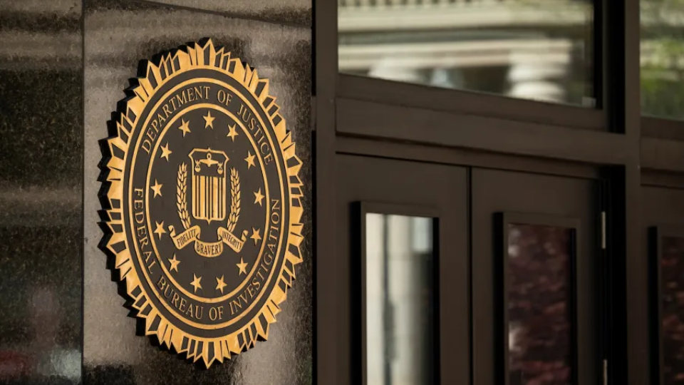 The metallic FBI seal mounted on a polished dark granite wall.
