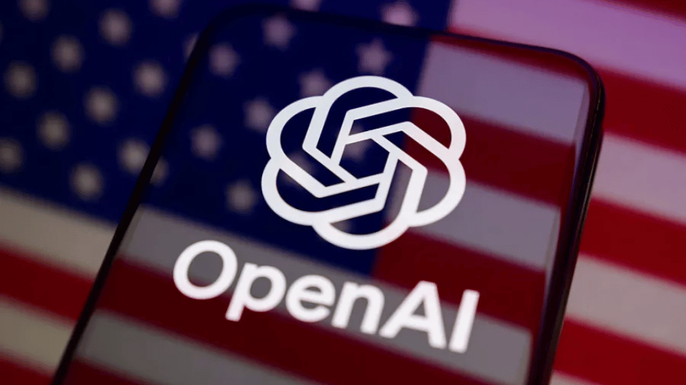 A smartphone displaying the OpenAI logo against a blurred American flag background.