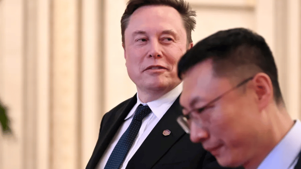 Elon Musk standing alongside an executive during a formal presentation.